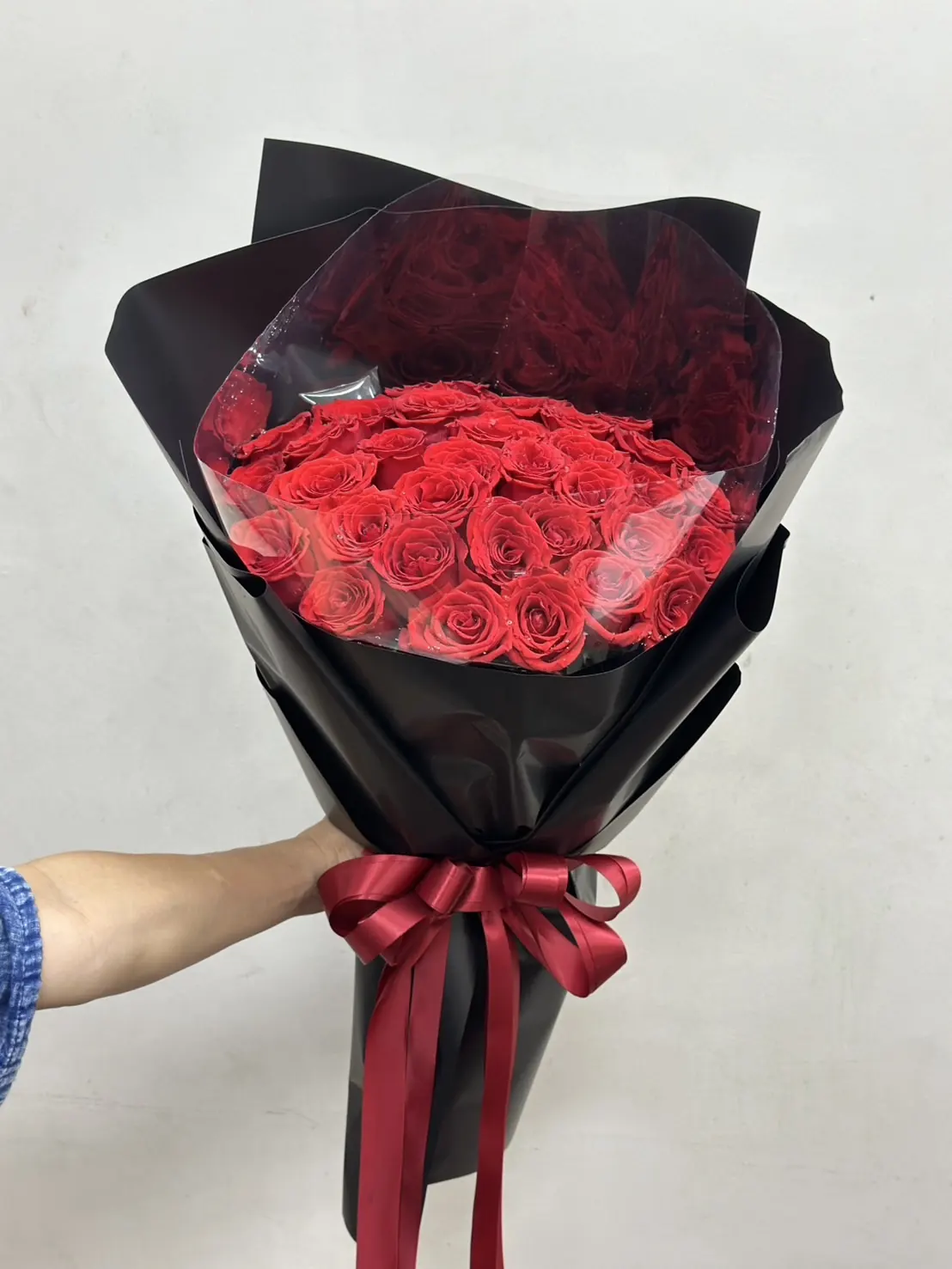 ลูกค้าถือช่อดอกไม้สีแดงที่จัดส่งจริงจาก Cmosa Flower
